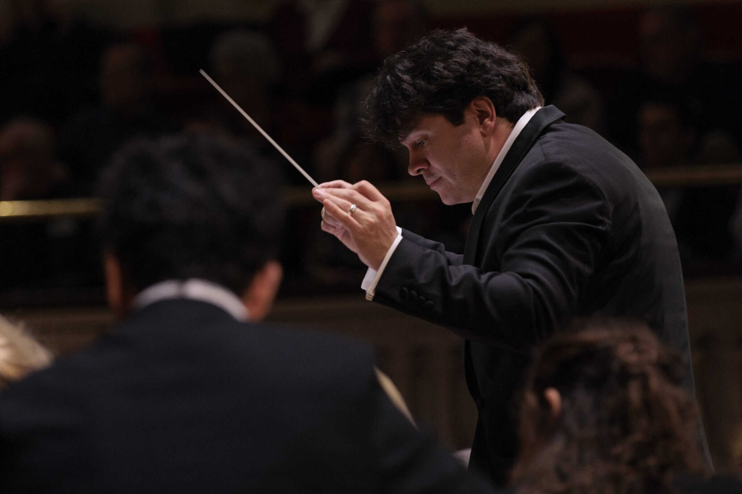 A close up of conductor leading an orchestra