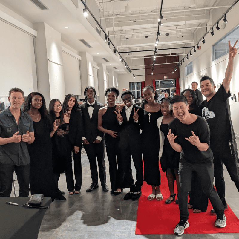 7 A group of students wearing all black standing in a lobby